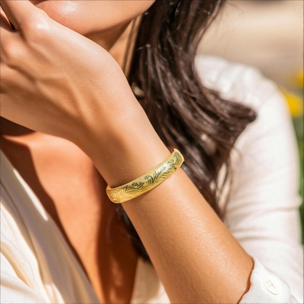 Engraved 14k yellow gold bangle featuring luxurious diamond accents, showcasing modern elegance and refined craftsmanship.