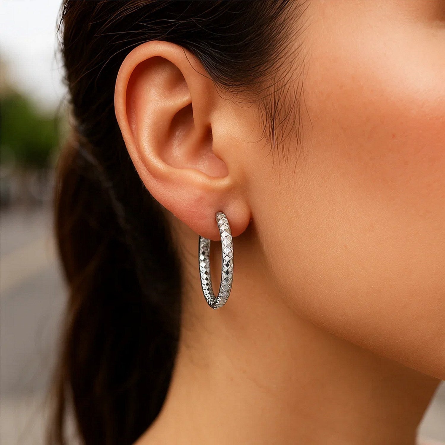 Sterling silver faceted hoop drop earrings with rhodium plating, showcasing modern elegance and exquisite craftsmanship.