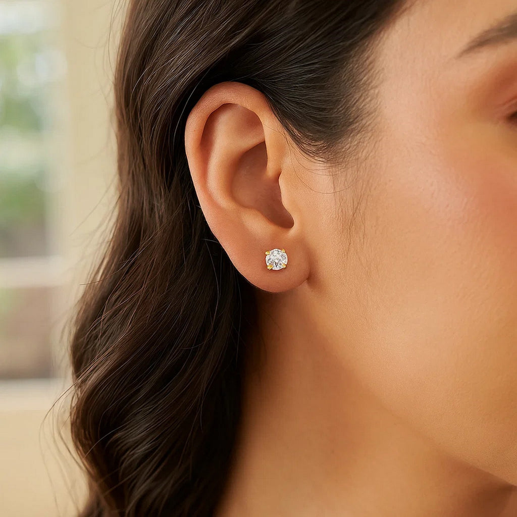 14k yellow gold polished faceted stud earrings with modern round design and elegant prong setting.