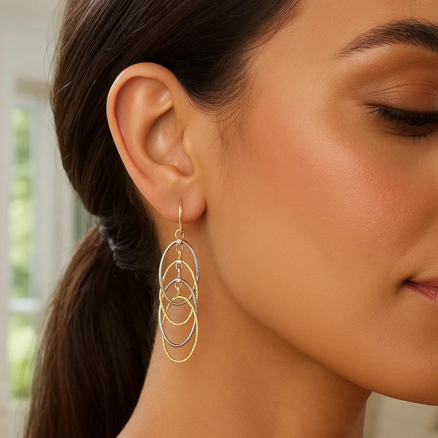 14k two-tone gold textured interlaced dangle earrings with modern design and elegant oval silhouette.