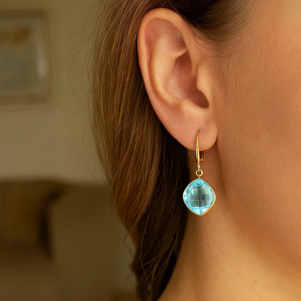 14k yellow gold drop earrings featuring blue topaz cushion briolettes in elegant bezel settings, modern design.