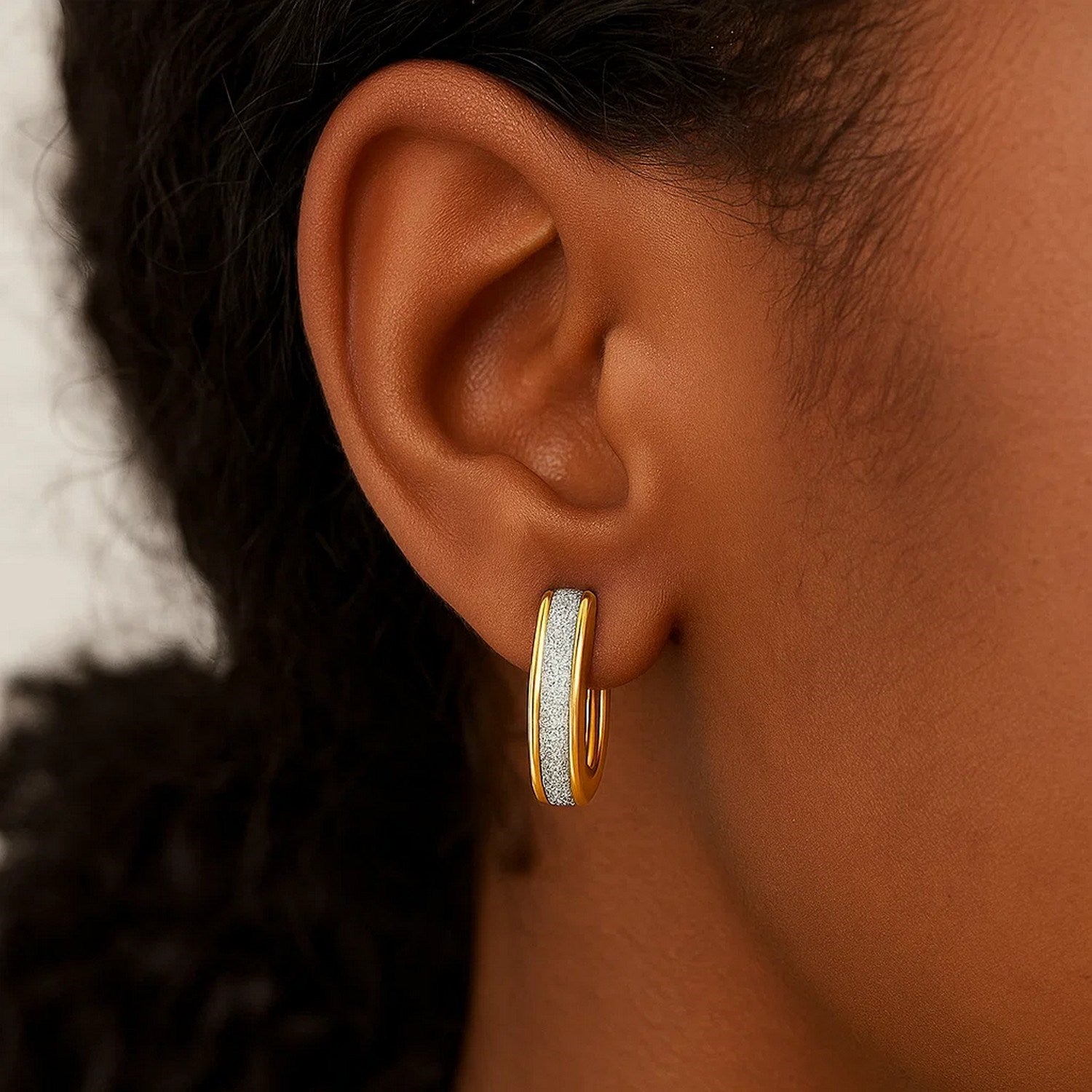 Polished 14k two-tone gold hoop earrings with a modern oval design, perfect for elegant occasions.