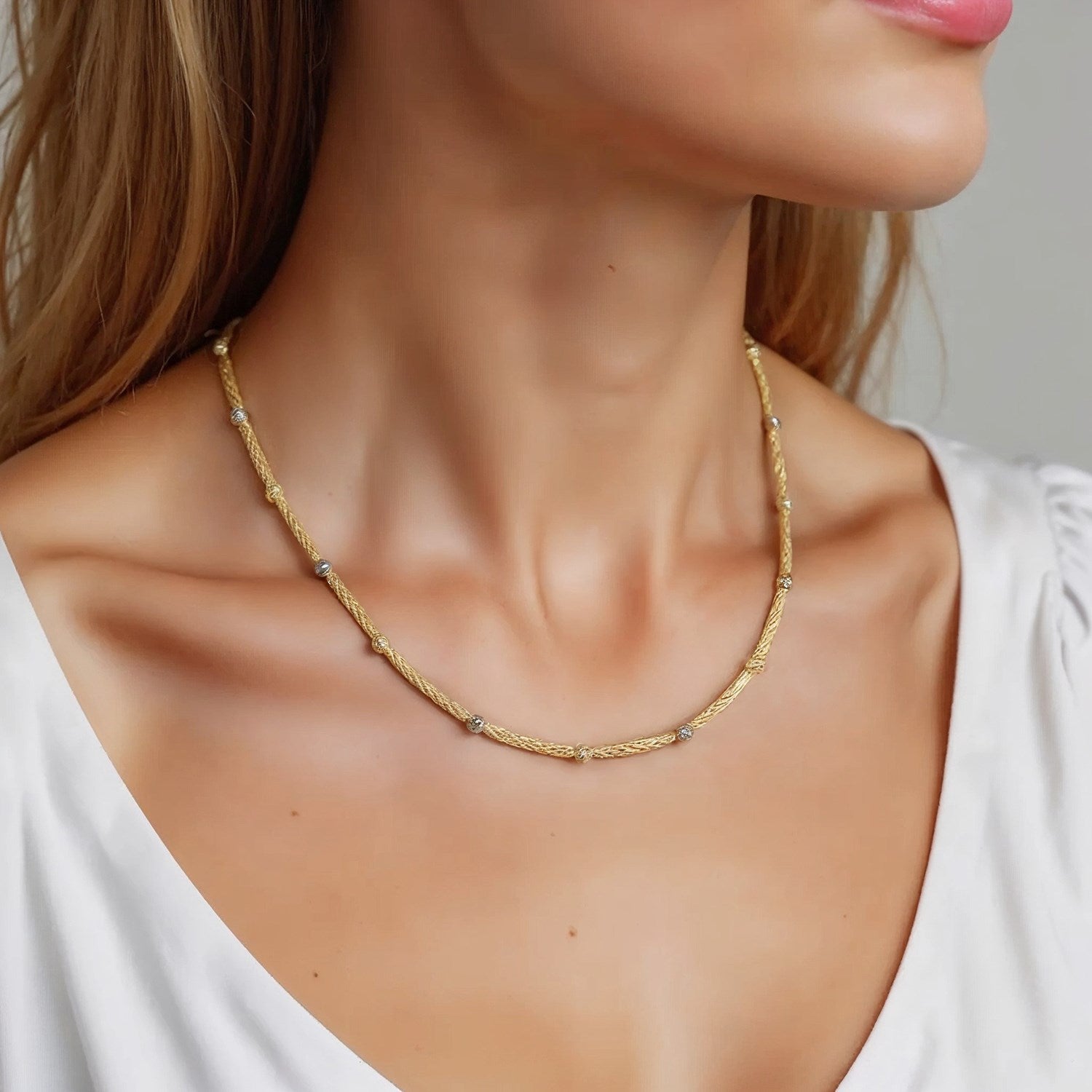 Two-tone 14k gold necklace featuring round diamonds and pearls in a modern design, showcasing elegance and luxury.
