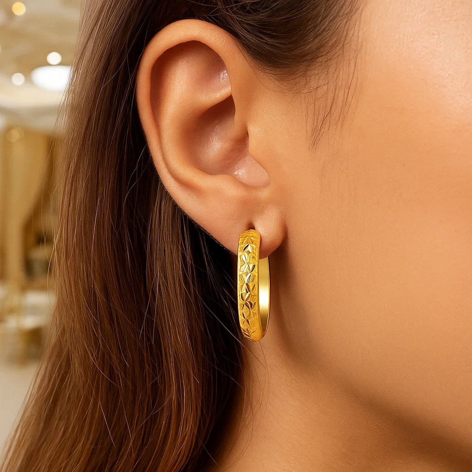 14k yellow gold hammered oval hoop earrings with a modern design, perfect for elegant everyday wear.