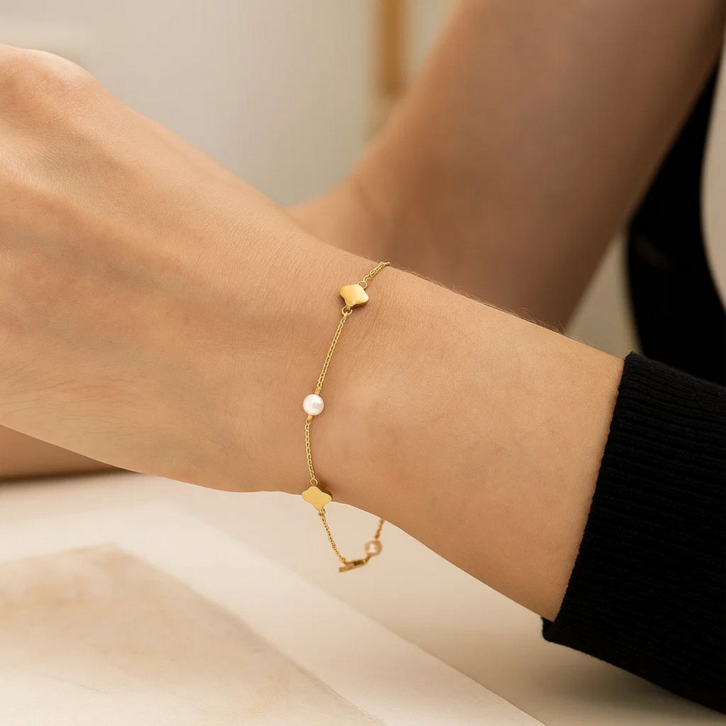 14k yellow gold minimalist bracelet featuring a delicate pearl clover design and elegant link detailing.