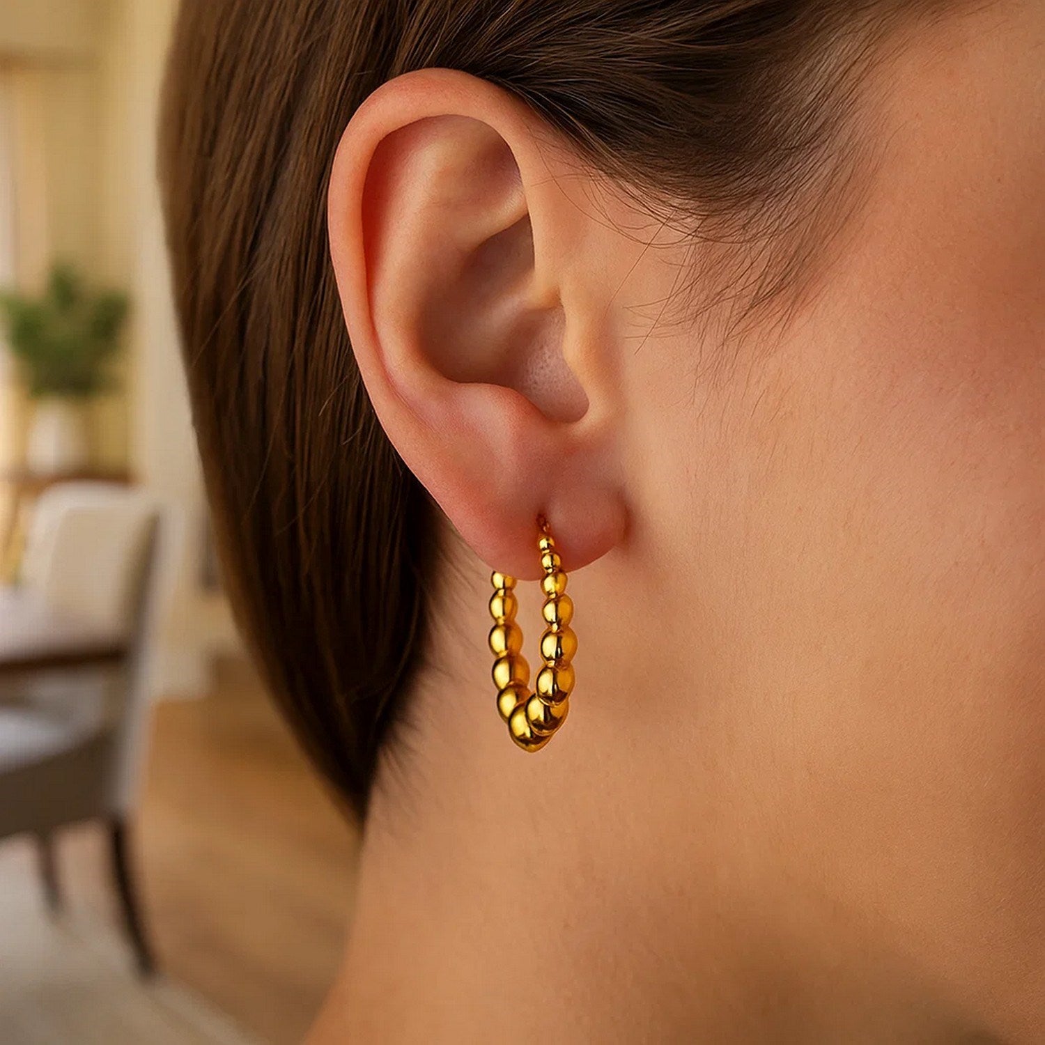14k yellow gold graduated sphere hoop earrings showcasing a modern design with elegant curvature and polished finish.