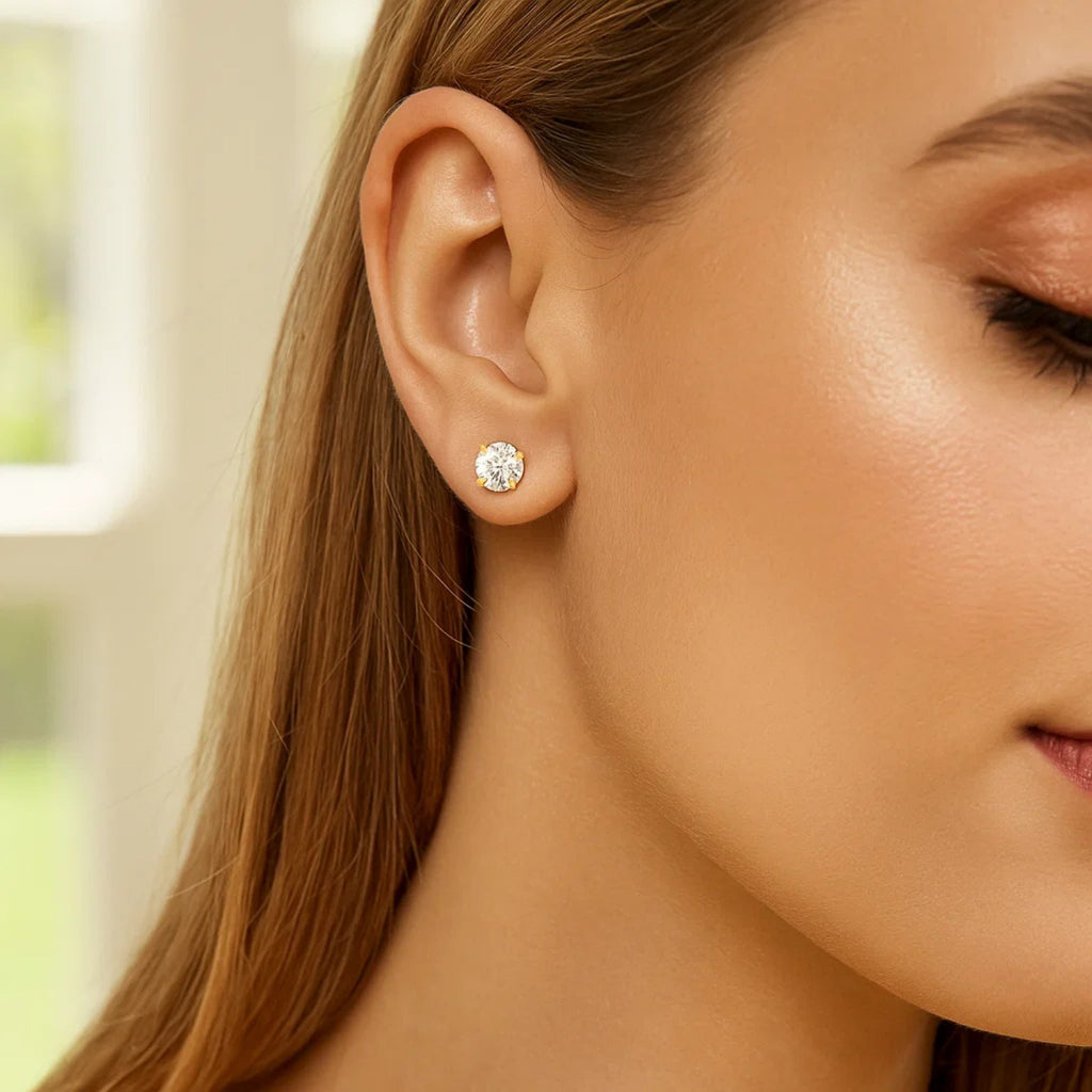 14k yellow gold polished faceted stud earrings featuring round white hue cubic zirconia in elegant prong setting.