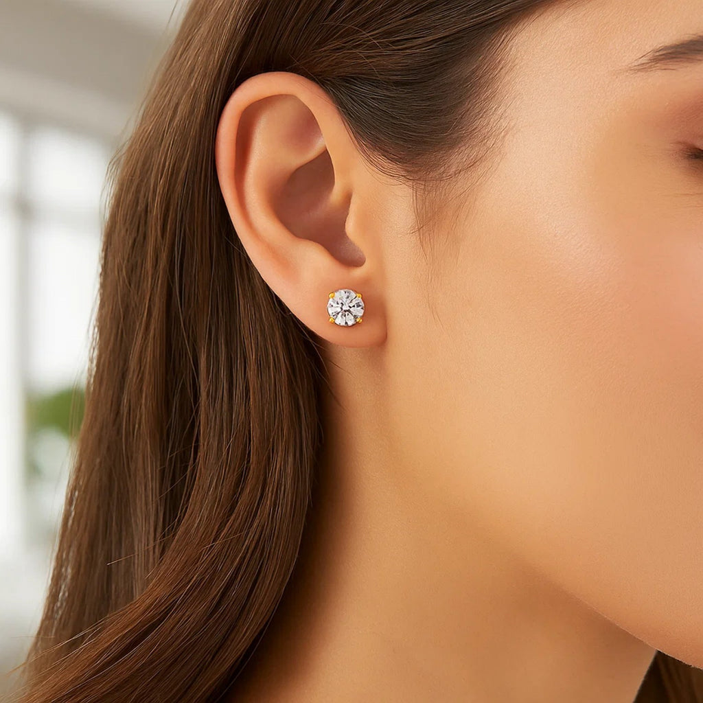 14k yellow gold polished faceted stud earrings featuring round white hue cubic zirconia in elegant prong settings.