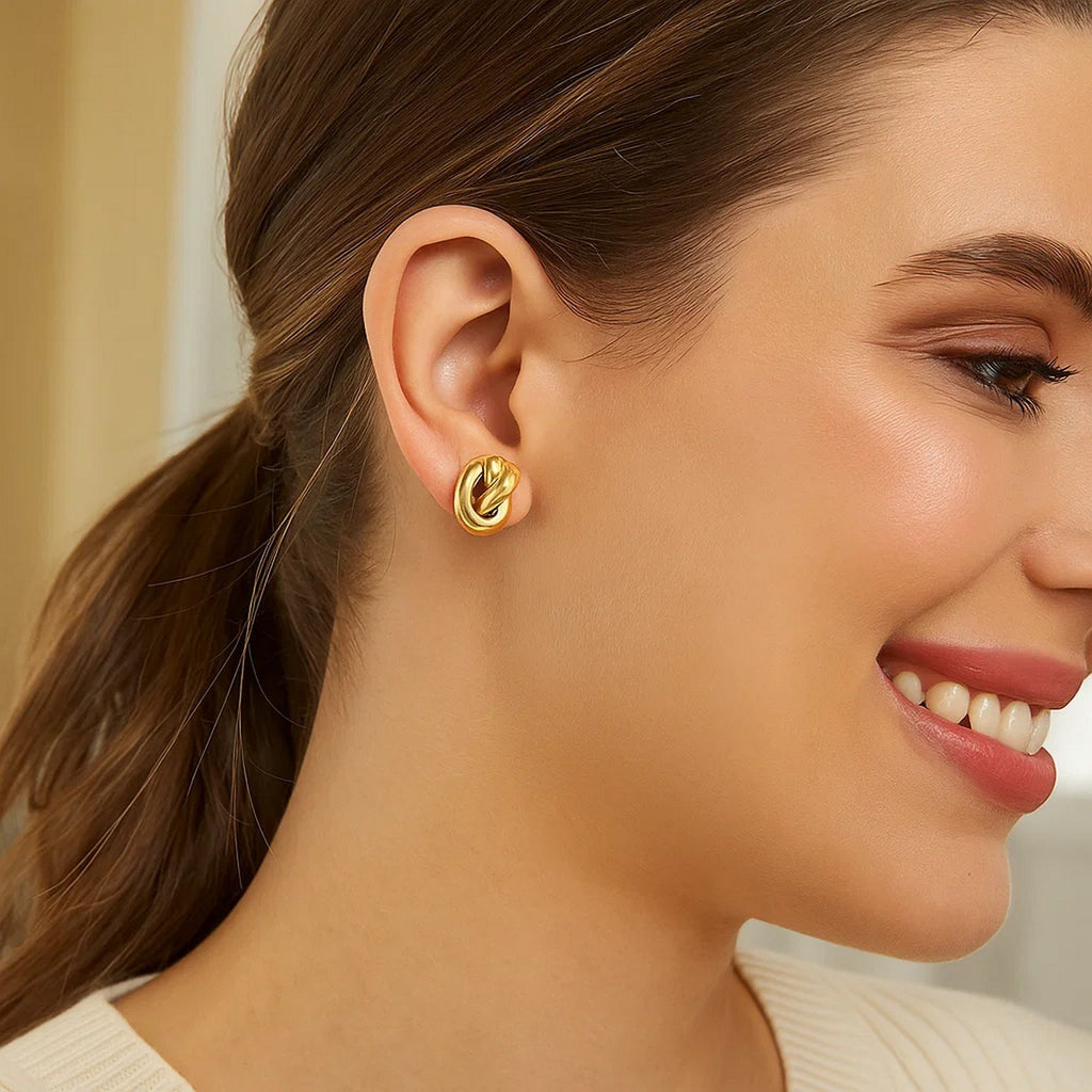 14k yellow gold polished knot stud earrings showcasing a modern design with a sleek, sophisticated finish.