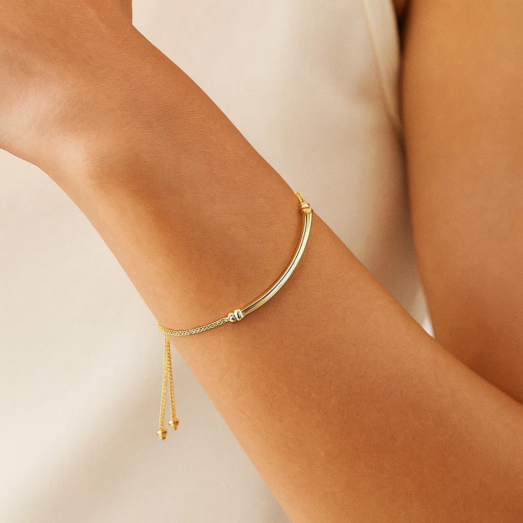 14k yellow gold lariat bracelet featuring a polished curved bar in a modern design, perfect for elegant layering.