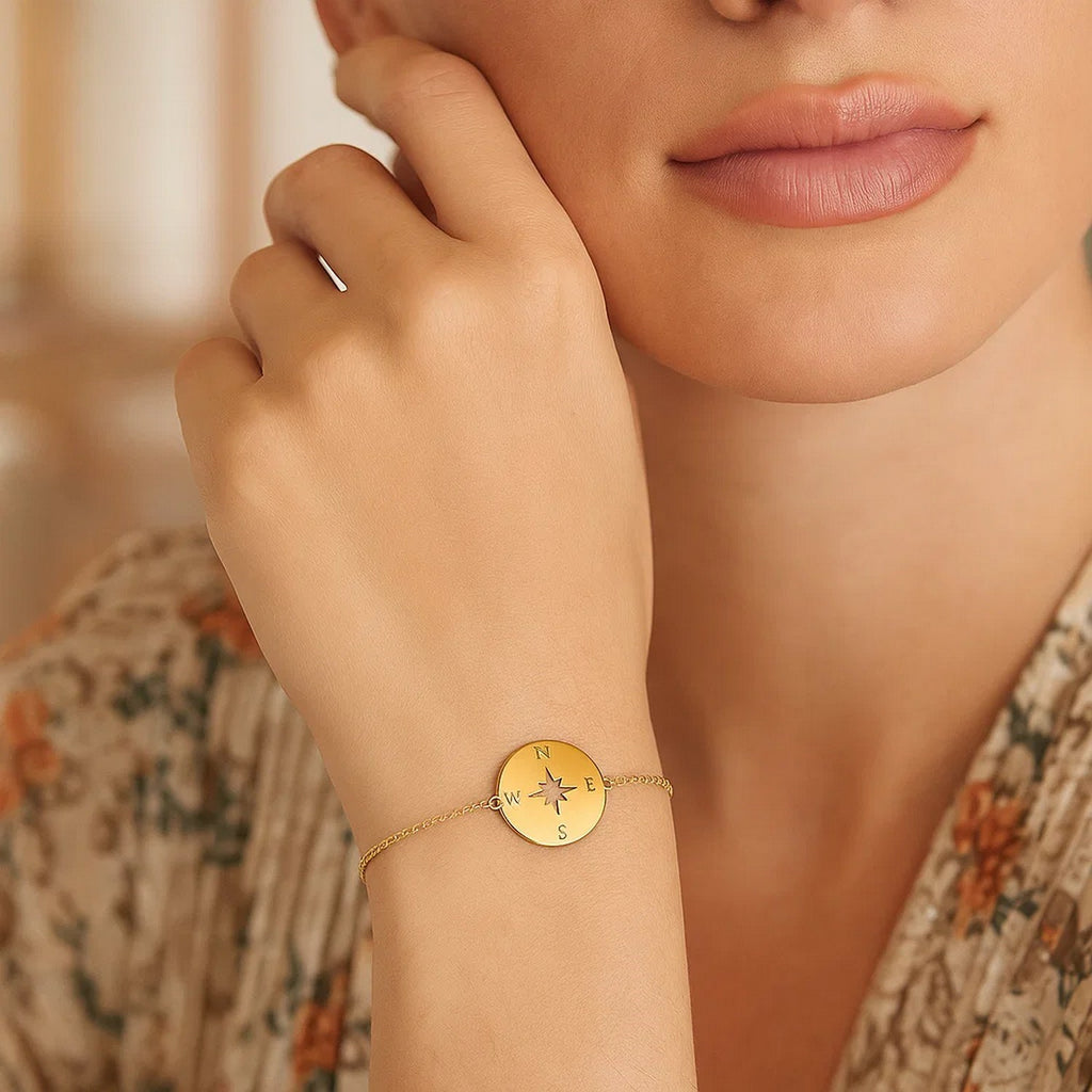 Elegant 14k yellow gold bracelet featuring a compass design on a delicate link chain, perfect for luxury style.