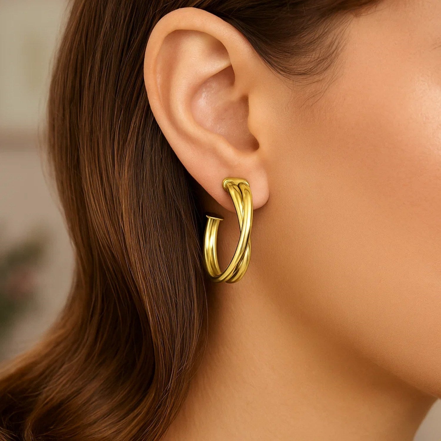 14k yellow gold textured crossover hoop earrings, showcasing a minimalist design with elegant curves and refined finish.
