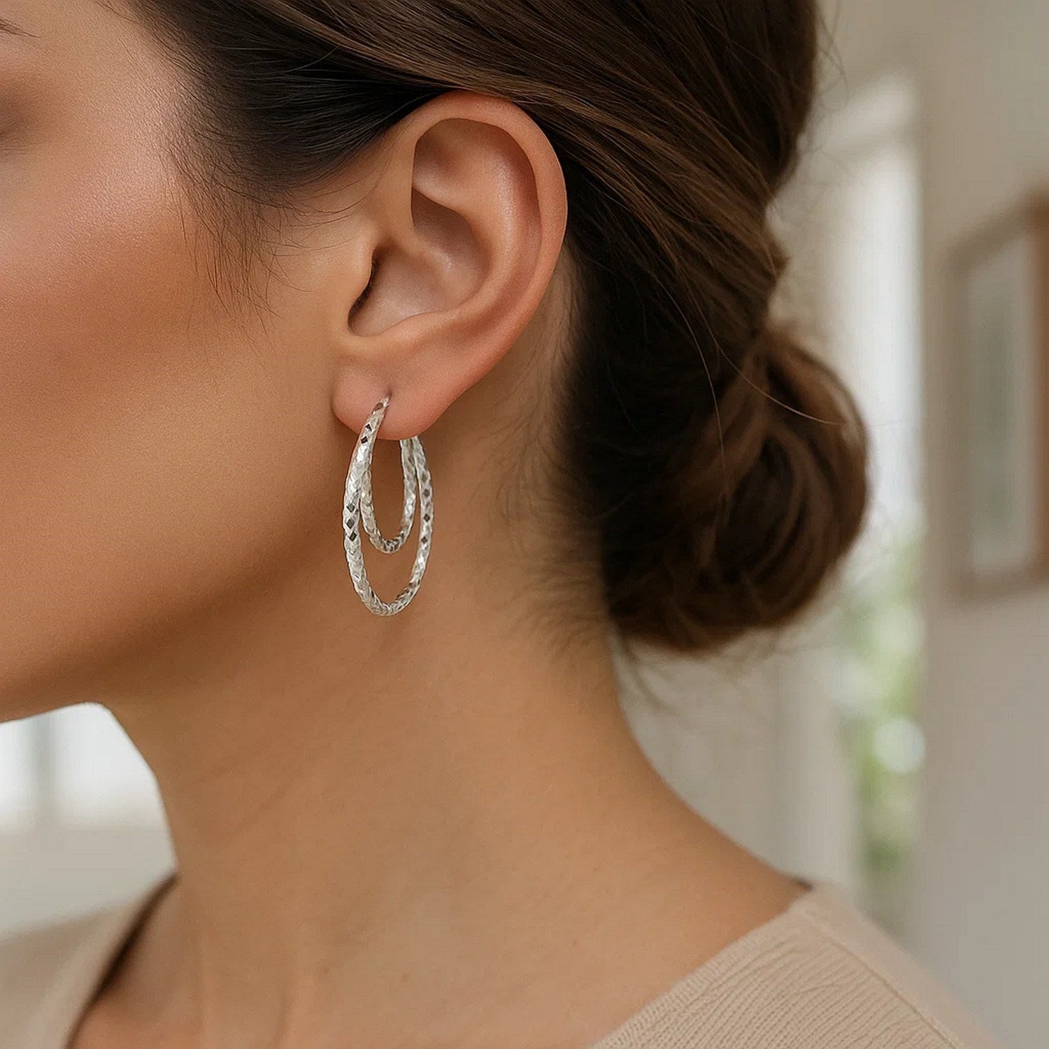 Sterling silver textured double oval hoop earrings, showcasing modern elegance and refined craftsmanship.