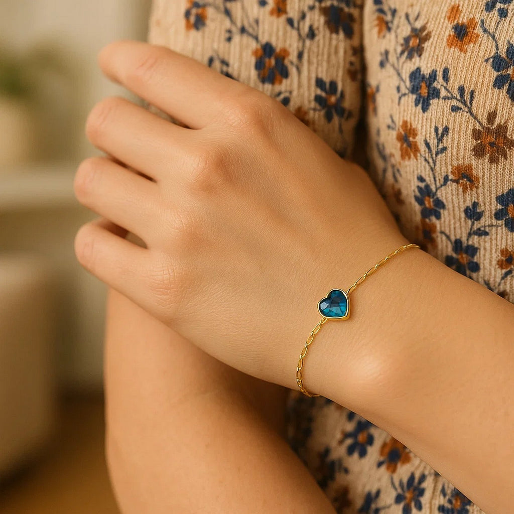 14k yellow gold bracelet featuring a heart-shaped blue topaz in a modern bezel setting, perfect for elegant occasions.