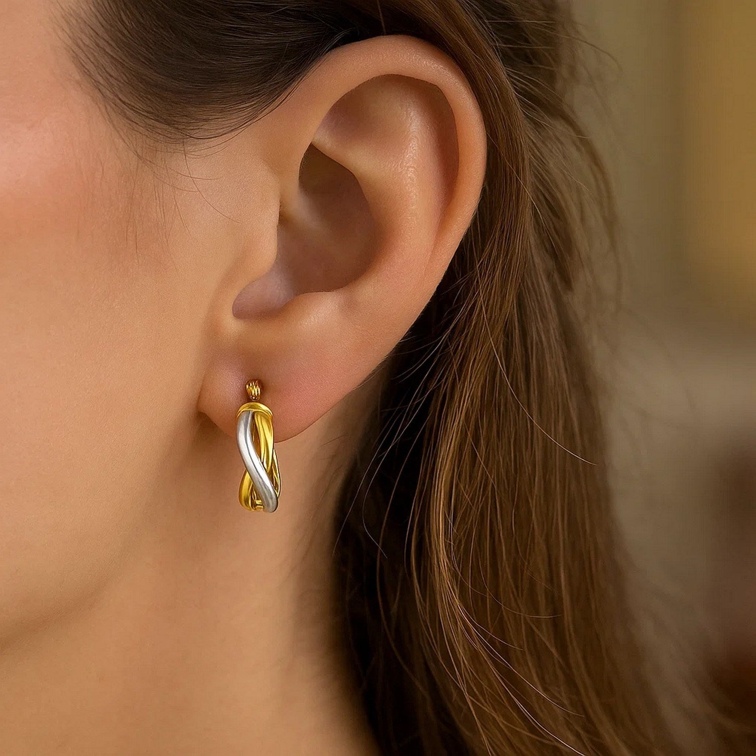 14k two-tone gold oval twisted hoop earrings, modern design with a luxurious finish and elegant silhouette.