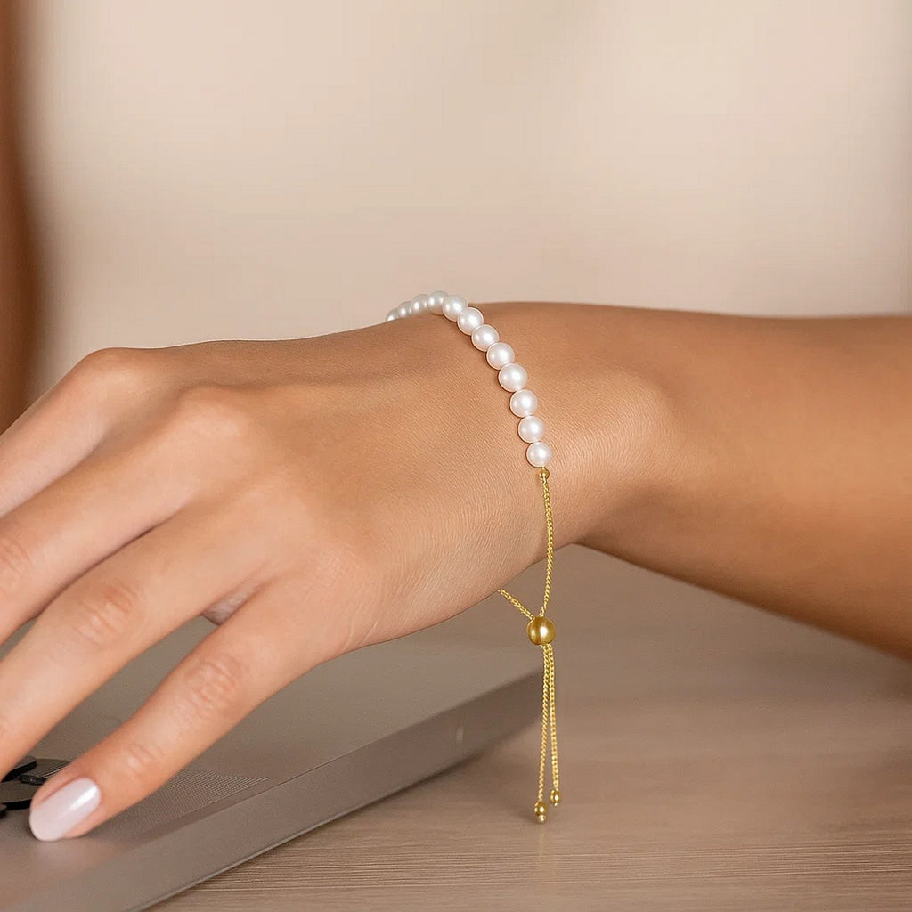 14k yellow gold adjustable friendship bracelet adorned with lustrous pearls in a modern round design.