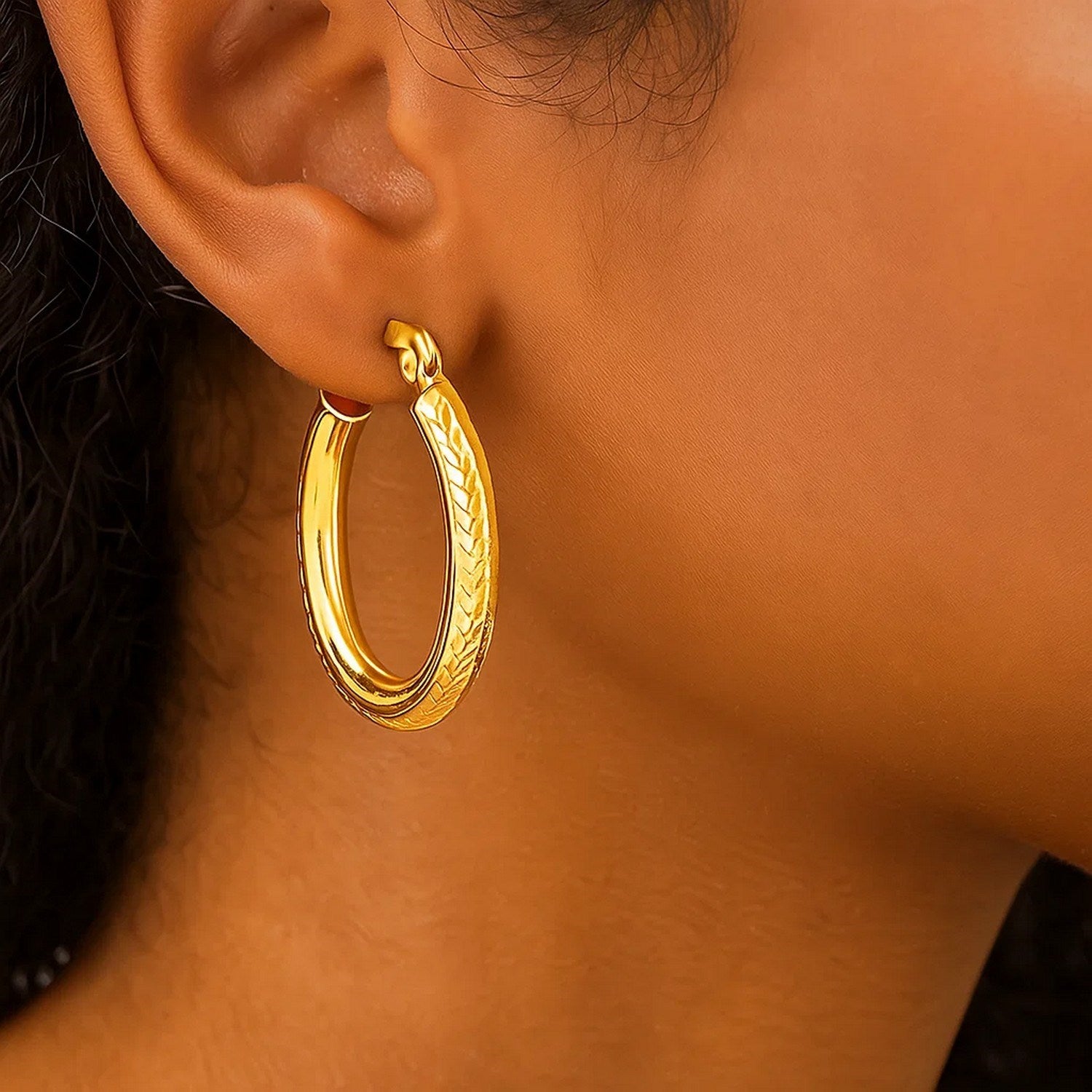 14k yellow gold diamond cut textured hoop earrings with elegant oval design, perfect for sophisticated occasions.