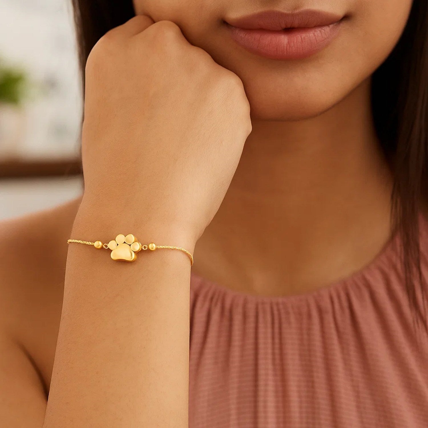Elegant 14k yellow gold adjustable bracelet featuring a delicate paw print design and a refined chain.