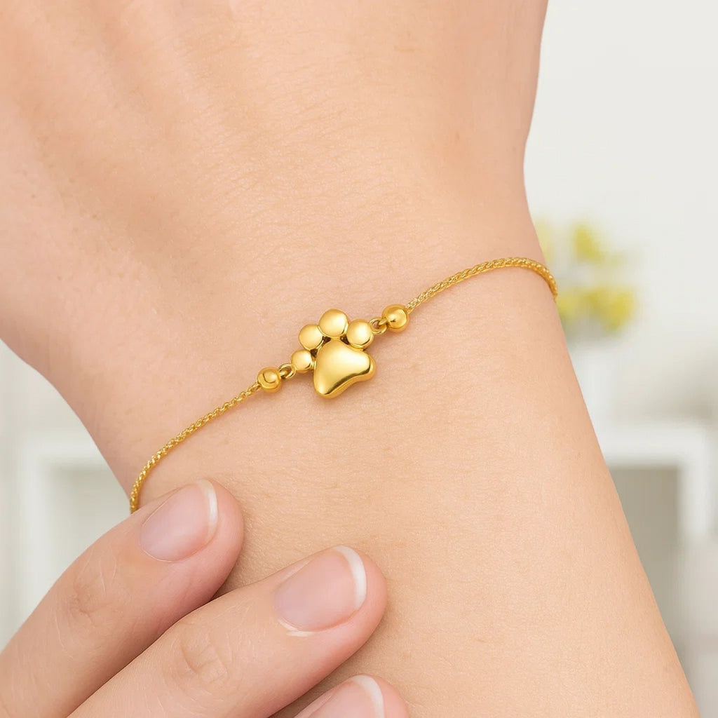 Elegant 14k yellow gold adjustable bracelet featuring a charming paw print design and delicate chain detail.