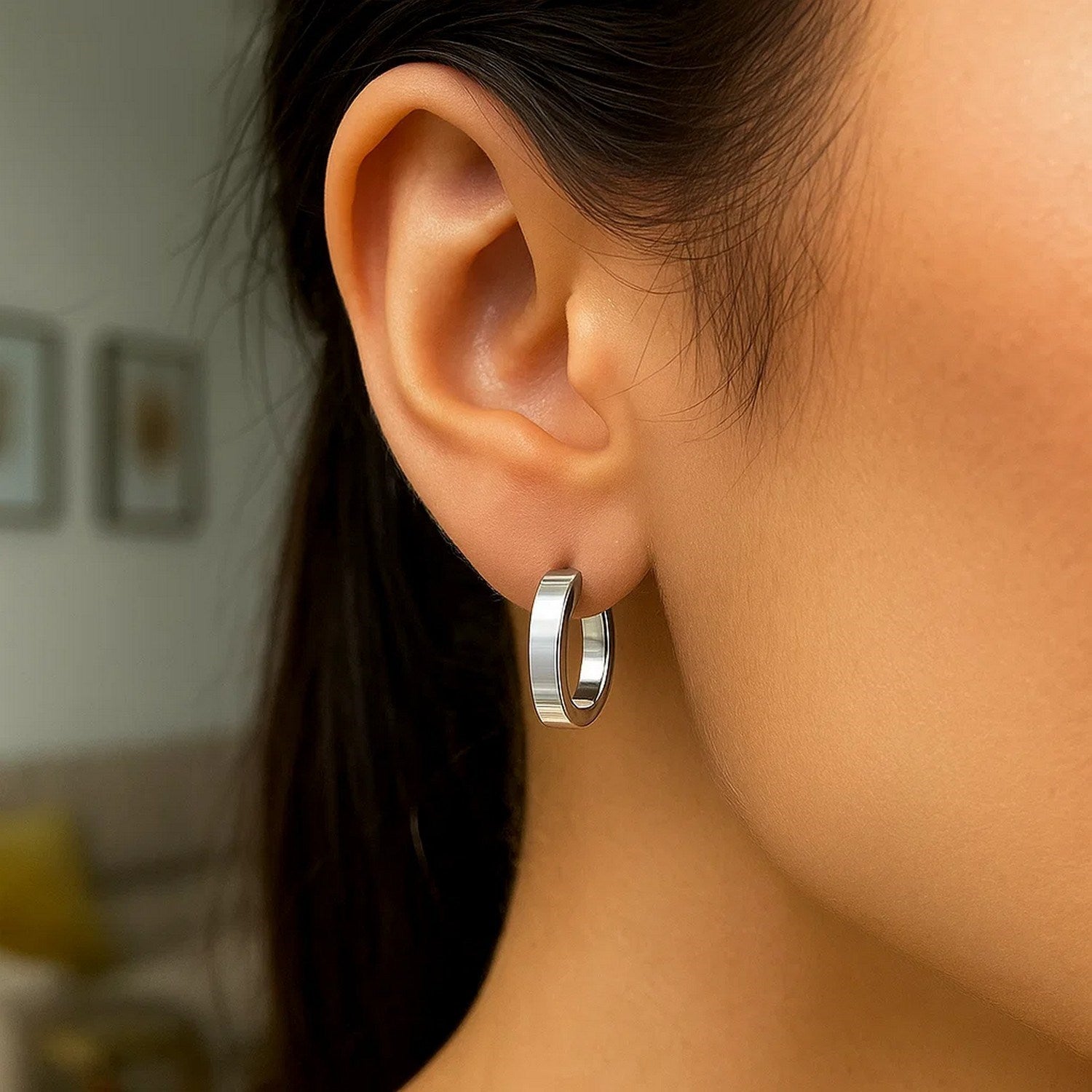 Sterling silver oval hoop earrings with rhodium plating, showcasing a modern flat style and elegant design.