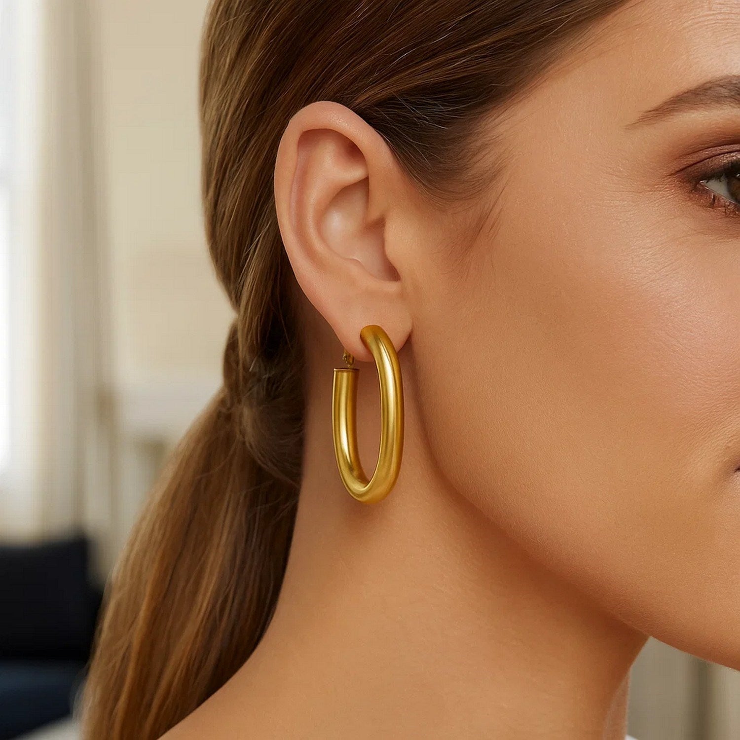 14k yellow gold textured oval hoop earrings showcasing modern elegance and refined craftsmanship.