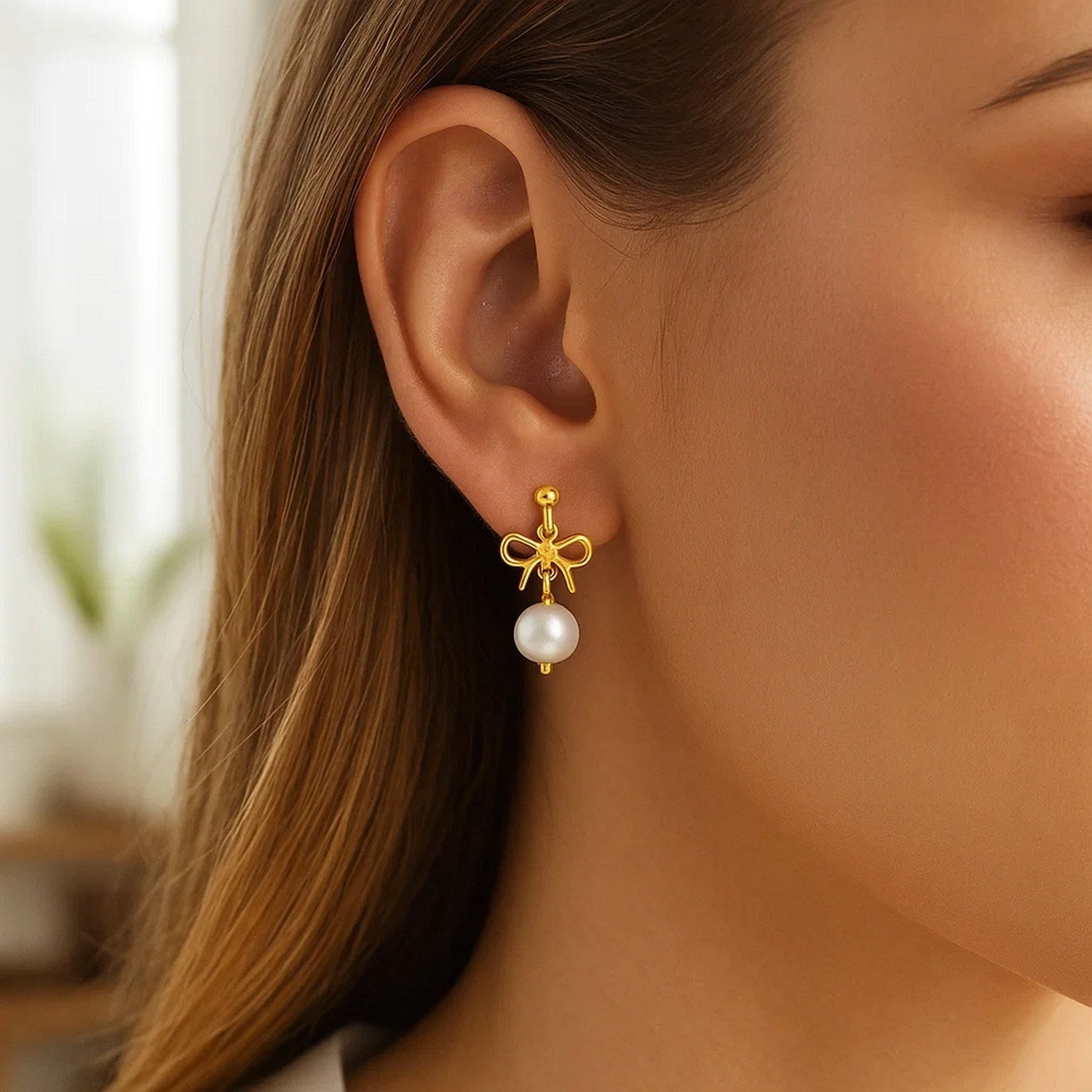 14K yellow gold drop earrings featuring elegant freshwater pearls in a classic bow design.