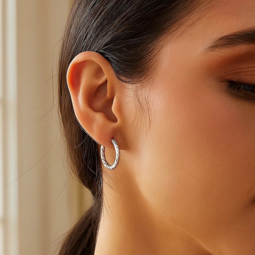 Sterling silver faceted hoop earrings with rhodium plating, showcasing a modern and elegant design.
