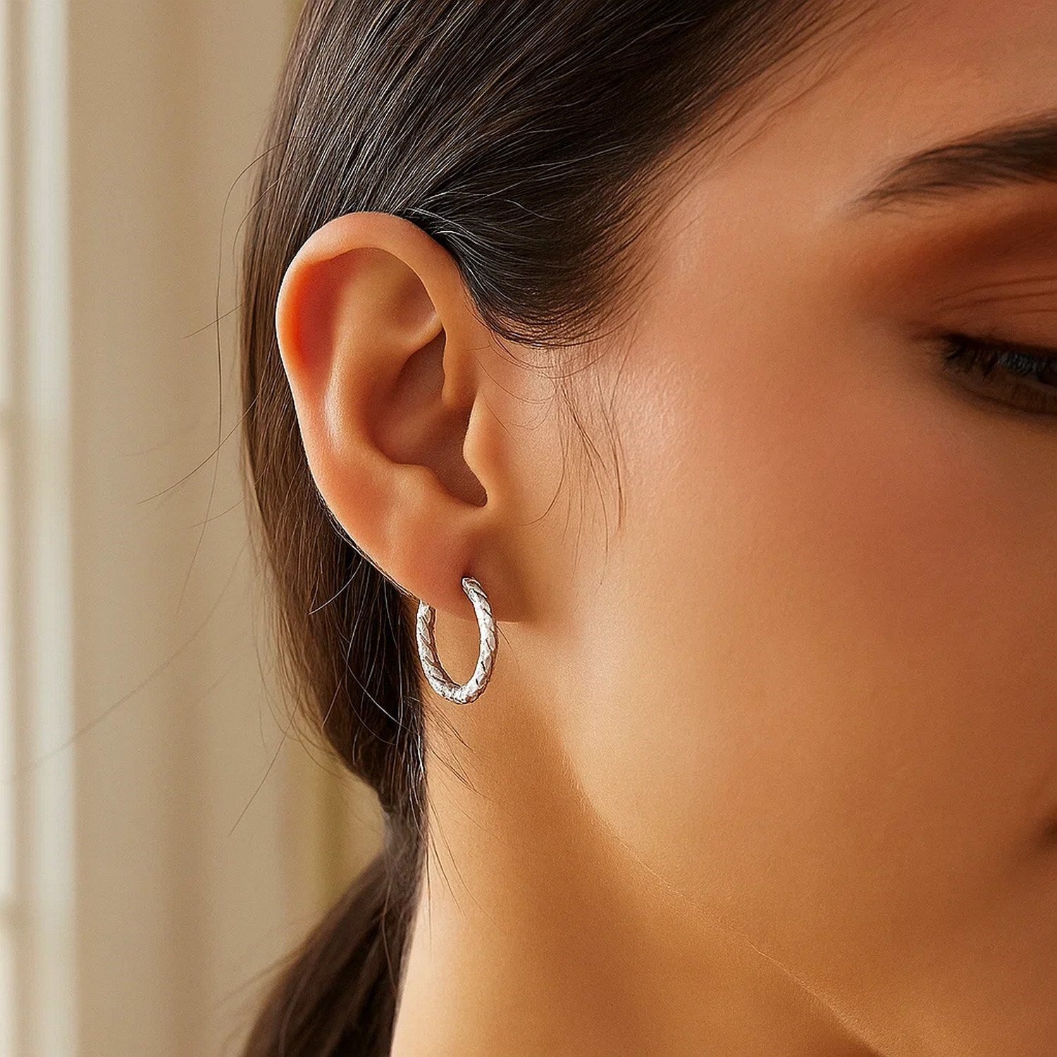 Sterling silver faceted hoop earrings with rhodium plating, showcasing a modern and elegant design.