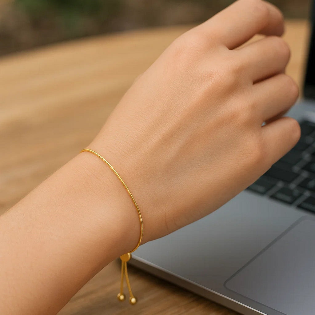 14k yellow gold adjustable lariat bracelet featuring a modern heart motif and delicate chain design.