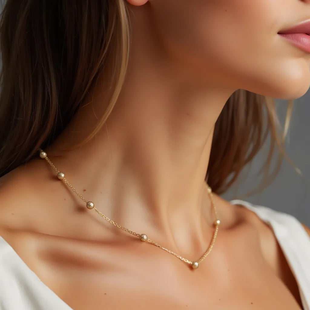 Textured 14k yellow gold Saturn bead necklace with modern chain design, showcasing luxurious craftsmanship and elegance.