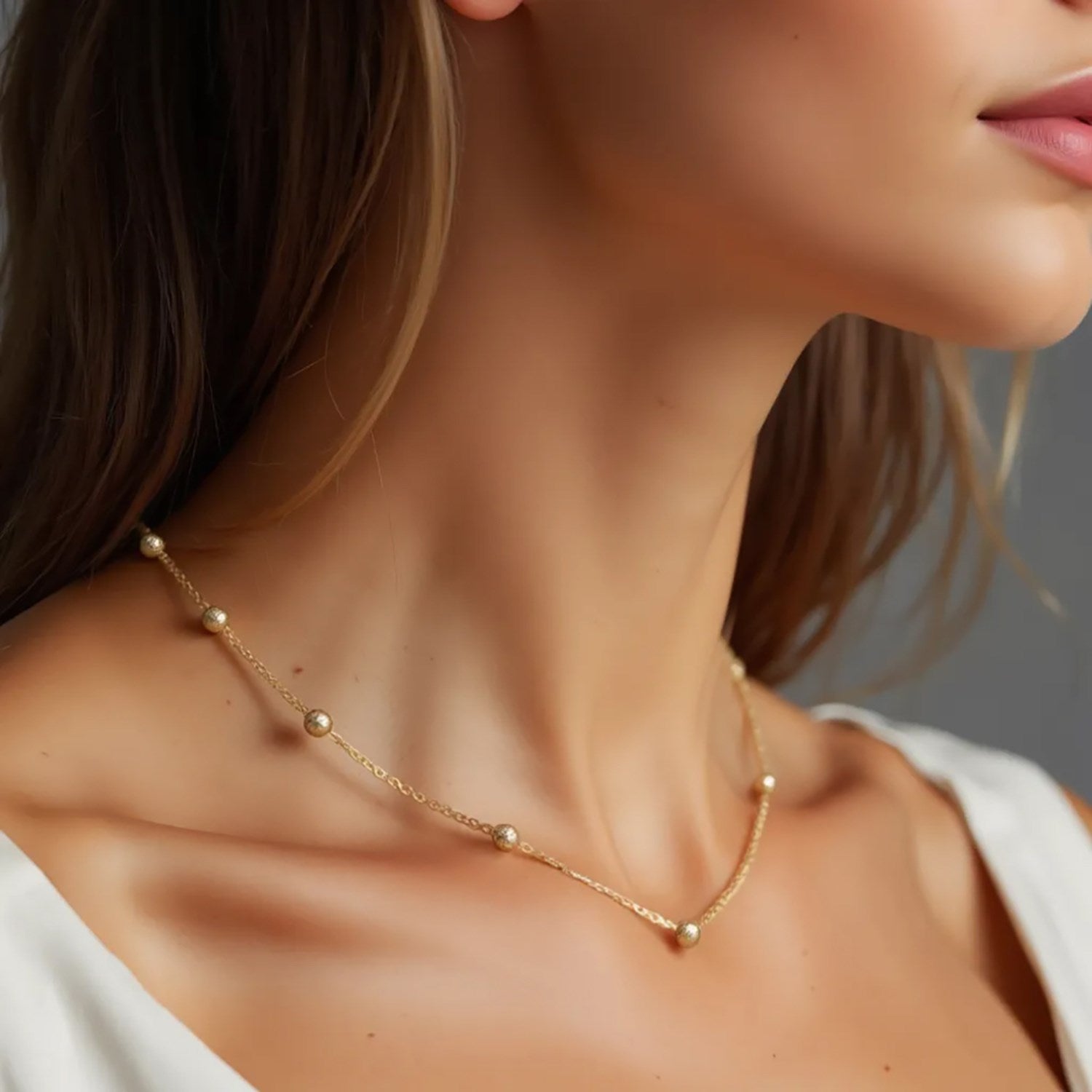 Textured 14k yellow gold Saturn bead necklace with modern chain design, showcasing luxurious craftsmanship and elegance.