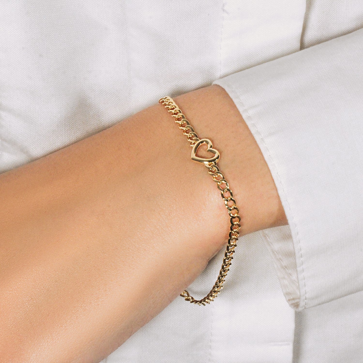 14k yellow gold curb chain bracelet featuring a modern heart design, 7 inches long and 3.40 mm wide.
