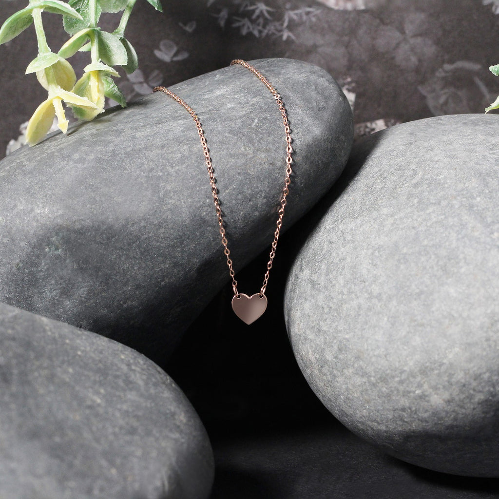 14k rose gold polished mini heart necklace with delicate chain, embodying classic elegance and timeless charm.
