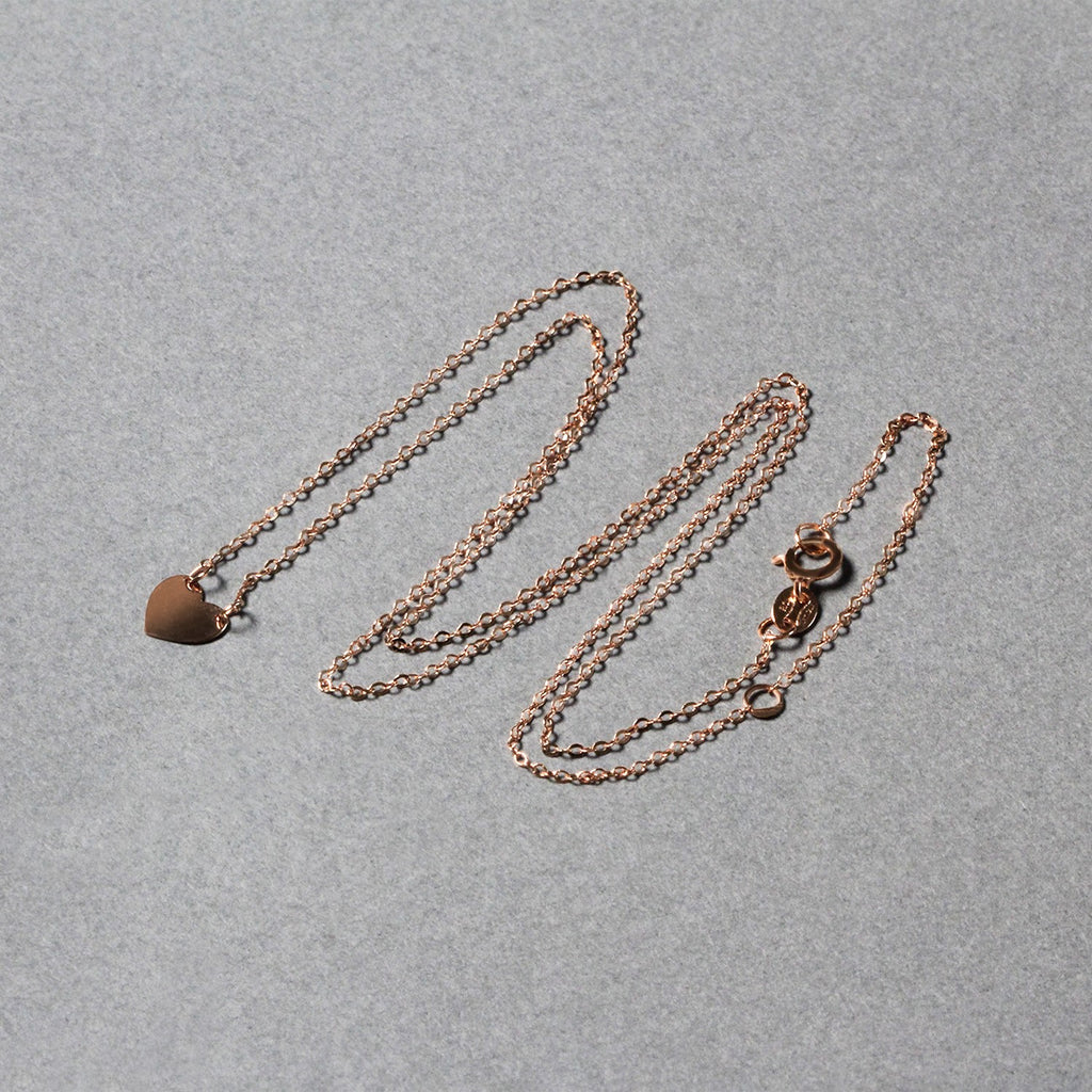 14k rose gold polished mini heart necklace with a delicate chain, embodying classic elegance and timeless charm.