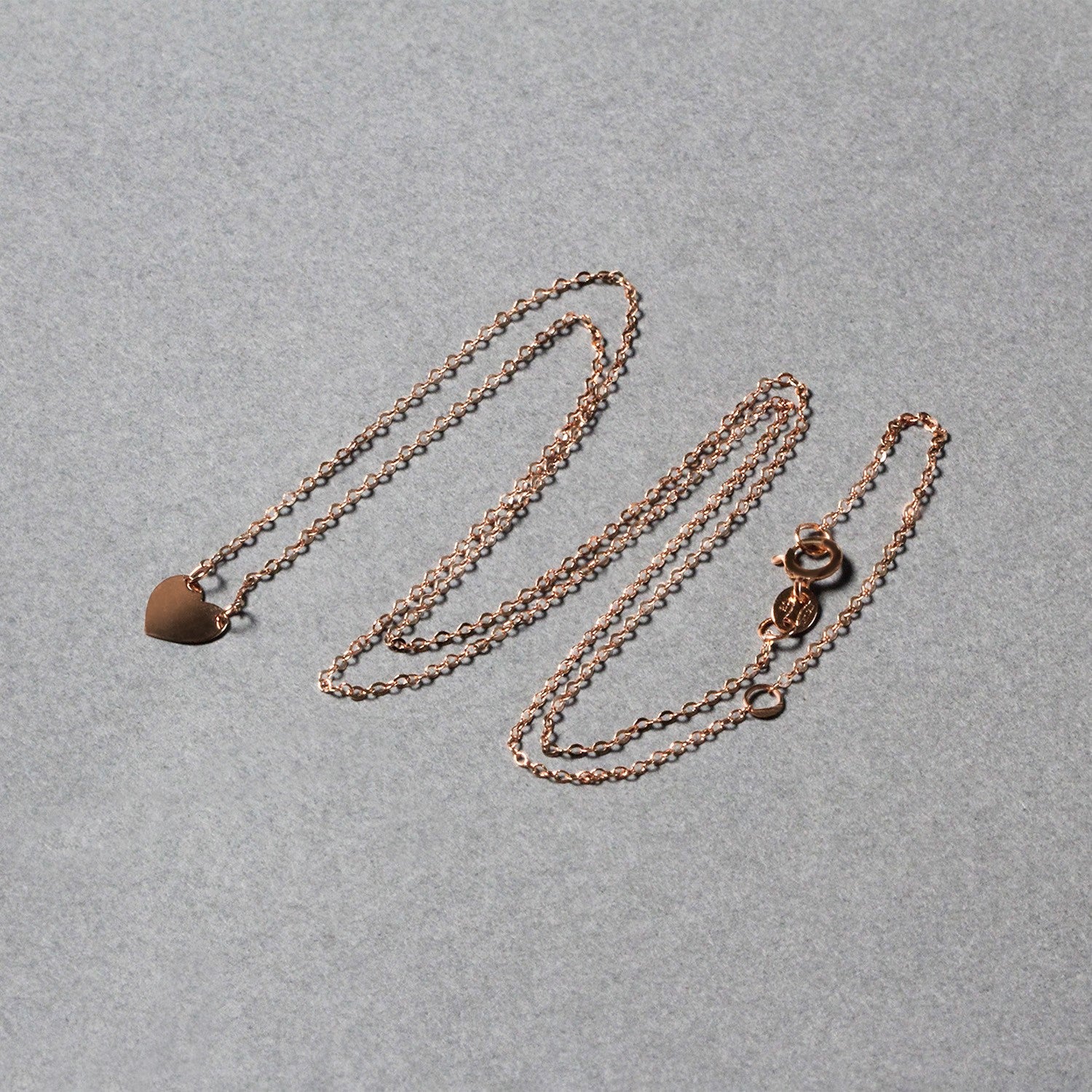 14k rose gold polished mini heart necklace with a delicate chain, embodying classic elegance and timeless charm.