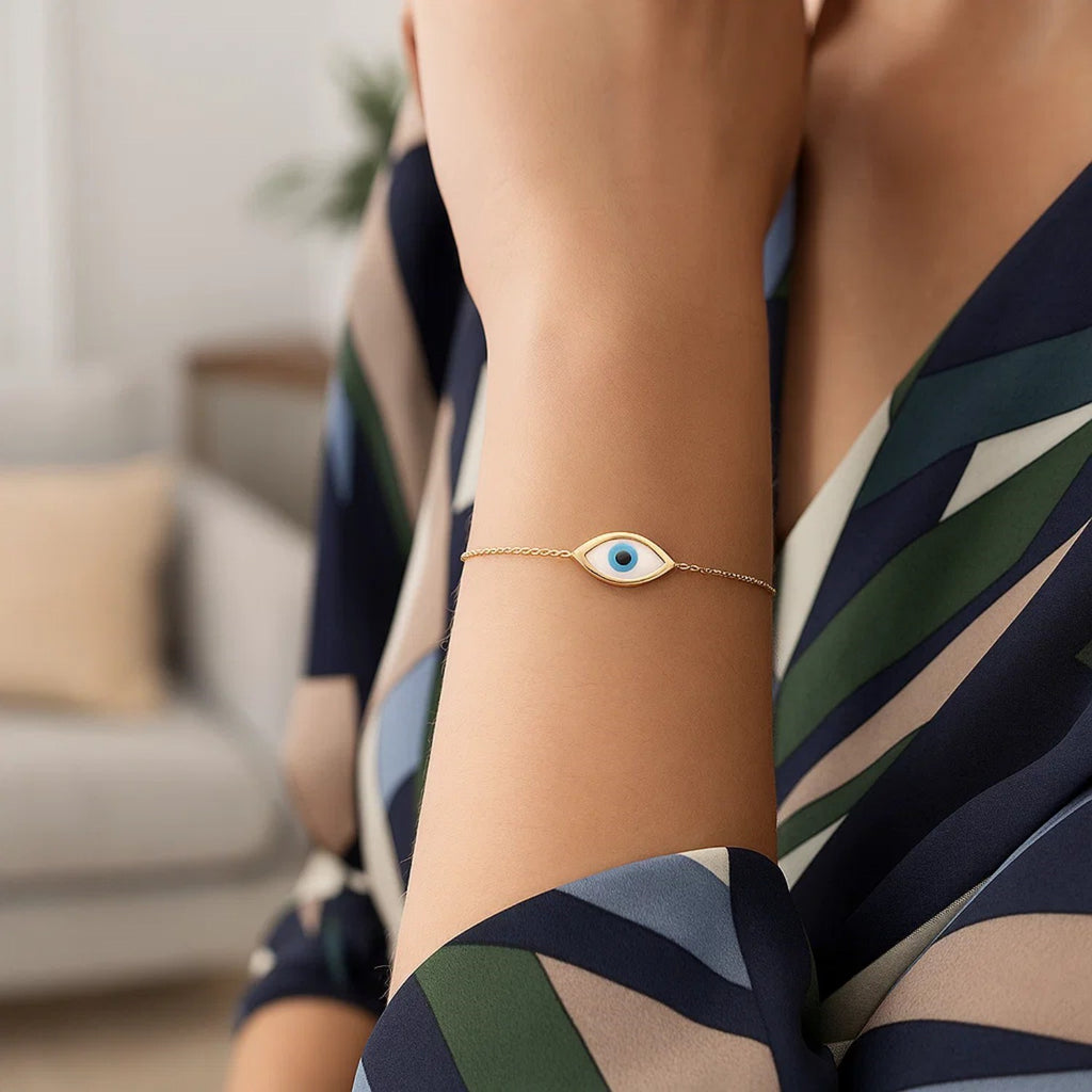 Elegant 14k yellow gold bracelet featuring a MOP evil eye design on a delicate chain, perfect for luxury jewelry lovers.