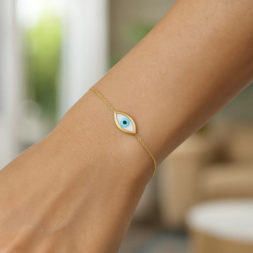 Elegant 14k yellow gold bracelet featuring a MOP evil eye design on a delicate chain, perfect for luxury styling.