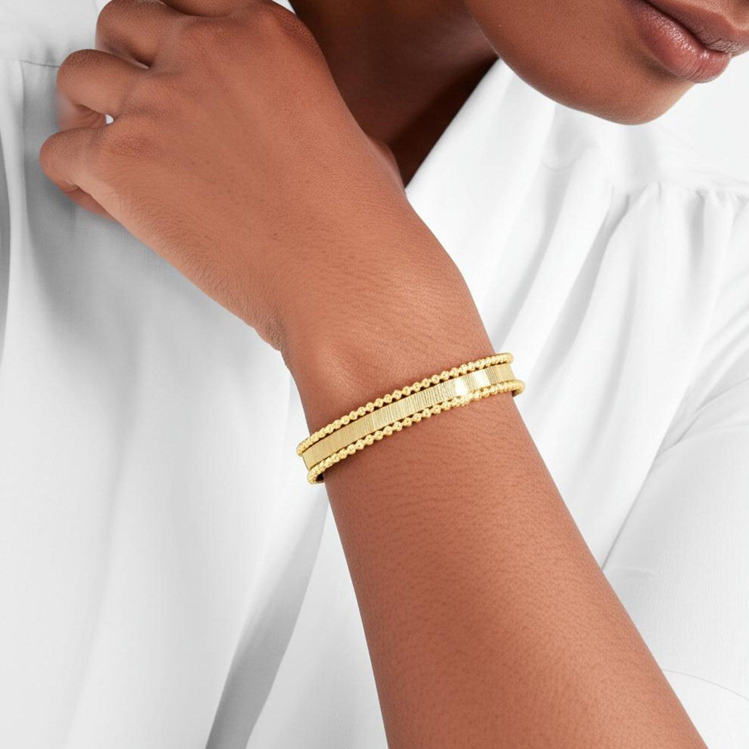 Smooth surface 14k yellow gold cuff bangle with modern design and elegant cushion cut chain detail.