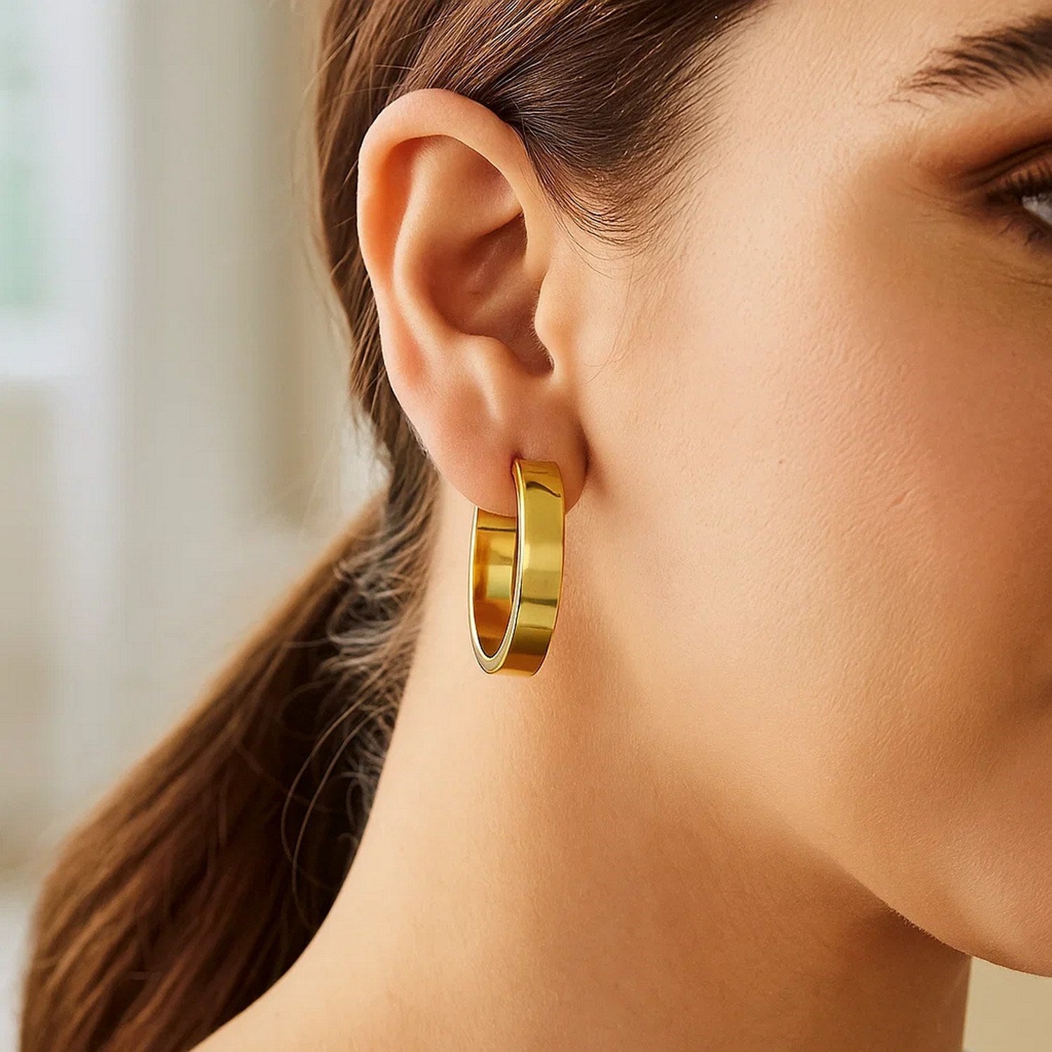 14K yellow gold medium tube hoop earrings with a sleek modern design, perfect for elegant everyday wear.