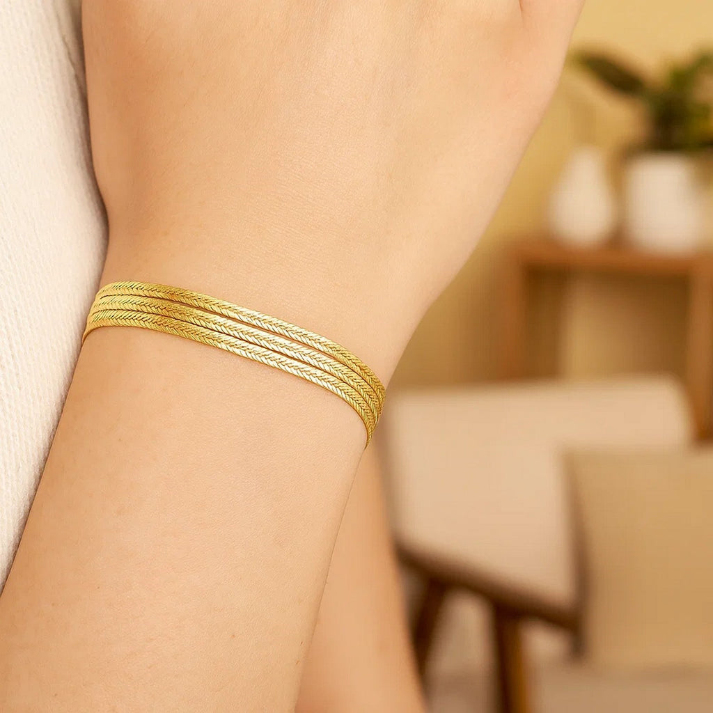 Elegant 14k yellow gold three-strand herringbone chain bracelet, 7 inches, showcasing a refined, luxurious design.
