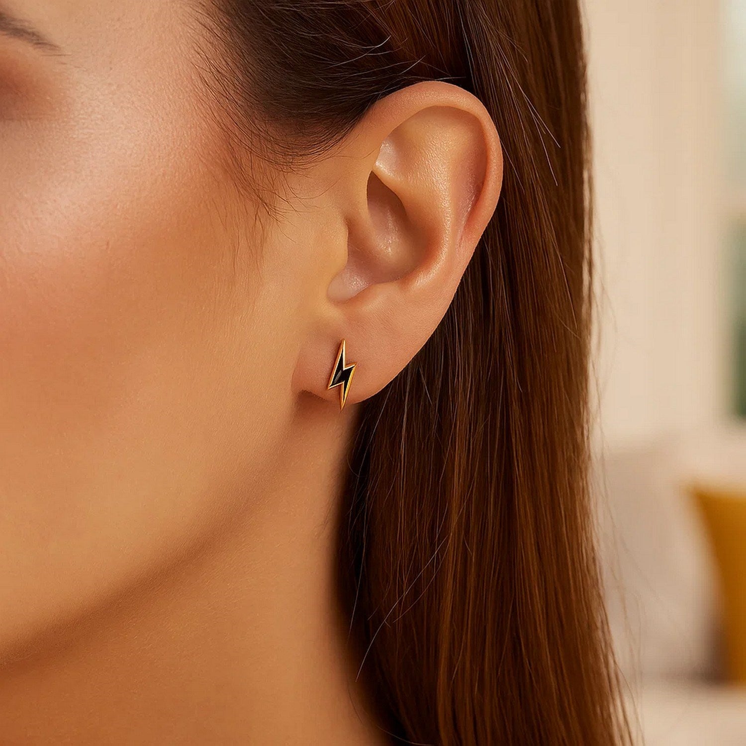 14k yellow gold stud earrings featuring modern black enamel lightning bolt design for a chic, edgy look.