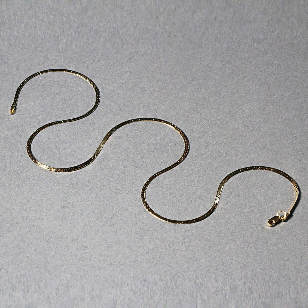 Elegant 14k yellow gold super flex herringbone chain, 1.50 mm, showcasing a sleek, refined design.