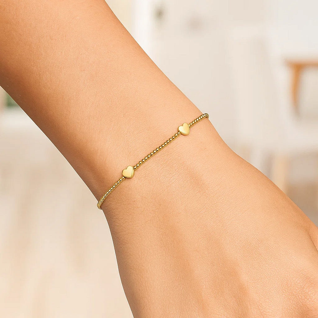 Elegant 14k yellow gold heart station bead bracelet showcasing a luxurious design with refined sophistication.