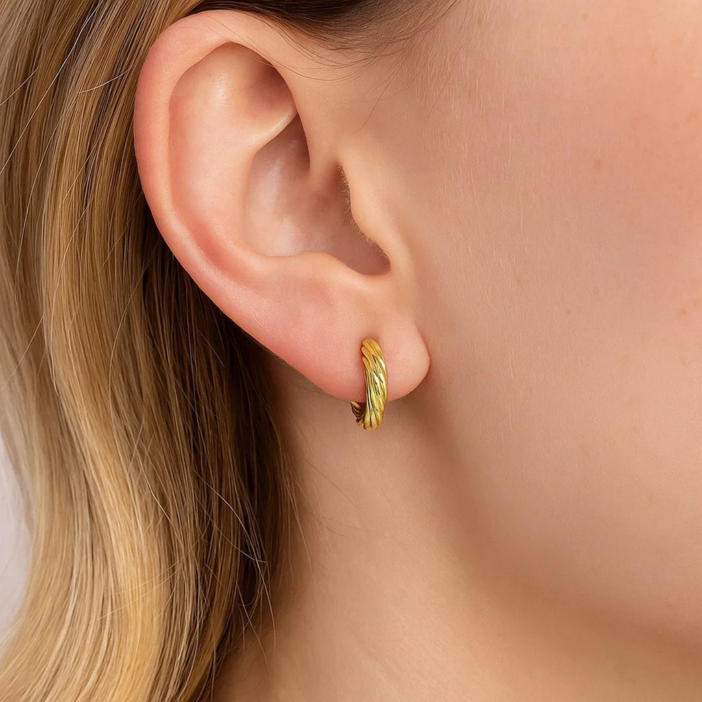 14k yellow gold petite twisted hoop earrings with a modern design, perfect for elegant everyday wear.