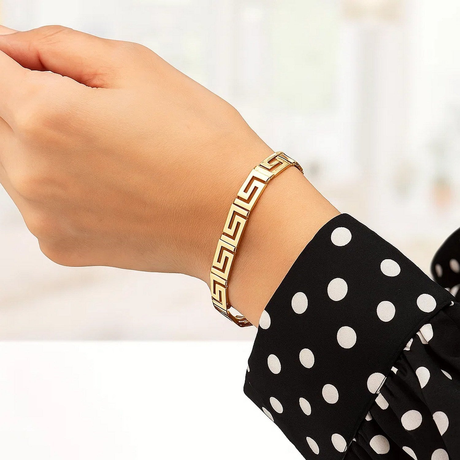Elegant 14k yellow gold bracelet featuring a fancy Greek key motif and a delicate chain design.