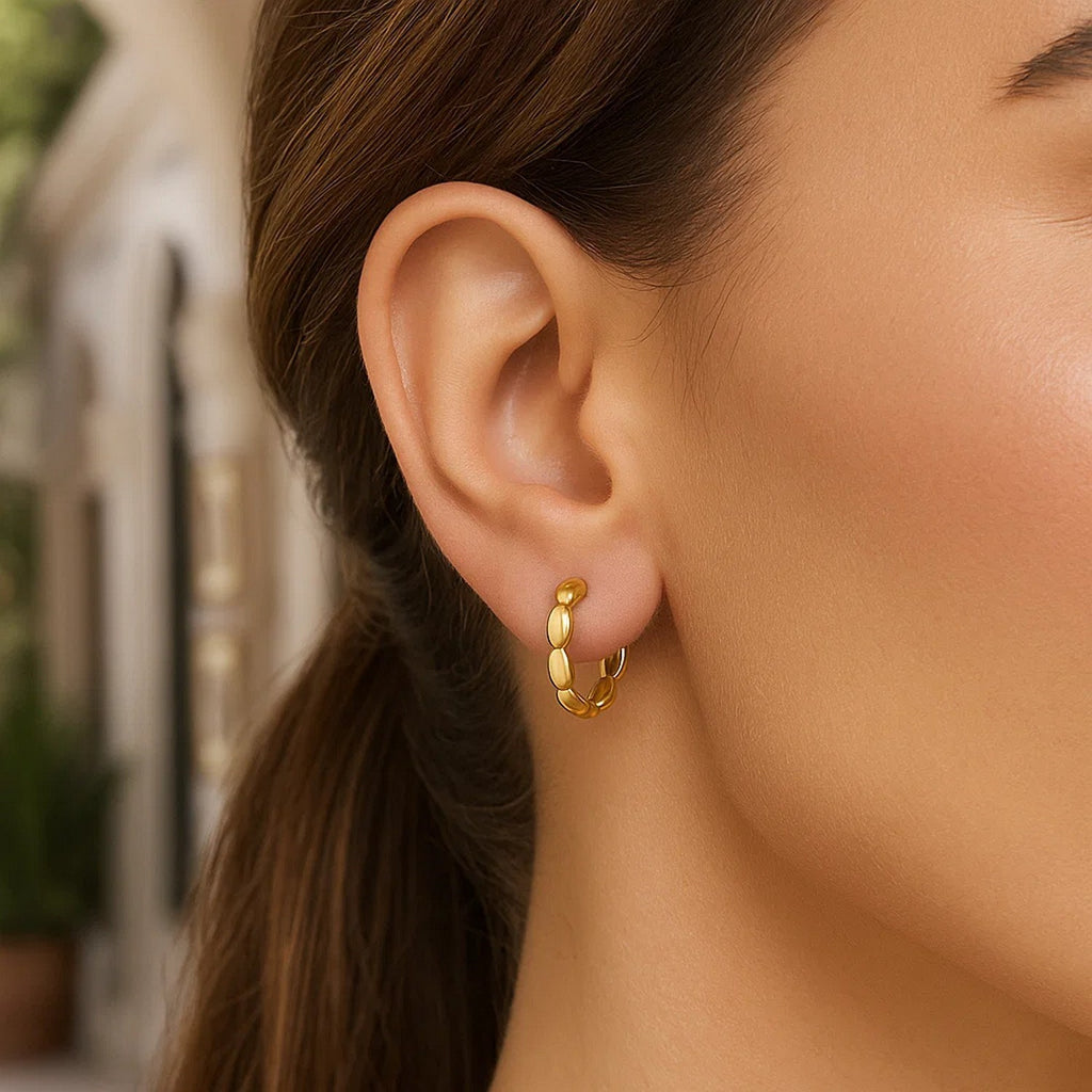 14k yellow gold medium rice hoop earrings showcasing a modern design with elegant curvature and polished finish.