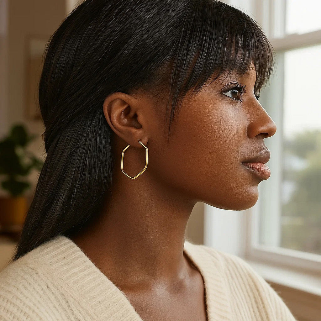 14K yellow gold hexagon hoop earrings with rounded edges, showcasing a modern and elegant design.