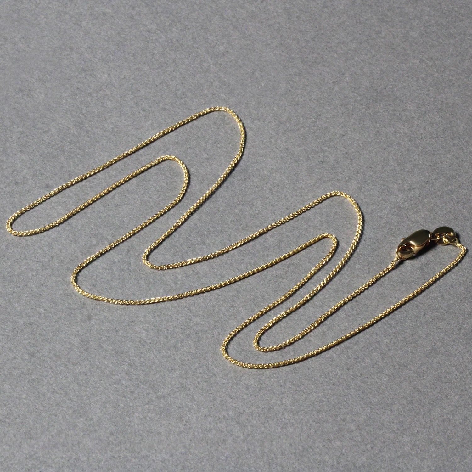 14k yellow gold round wheat chain featuring a modern design, perfect for layering or standalone elegance.