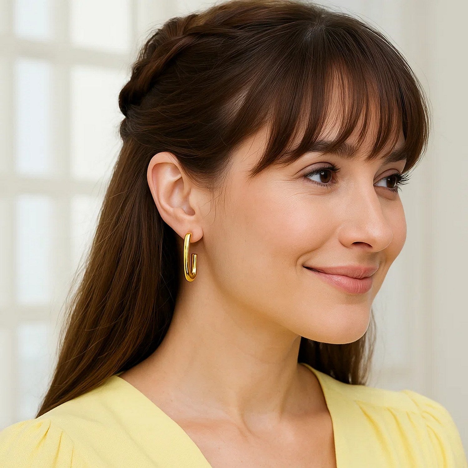 Polished 14k yellow gold hoop earrings showcasing a modern design and elegant shine from multiple angles.