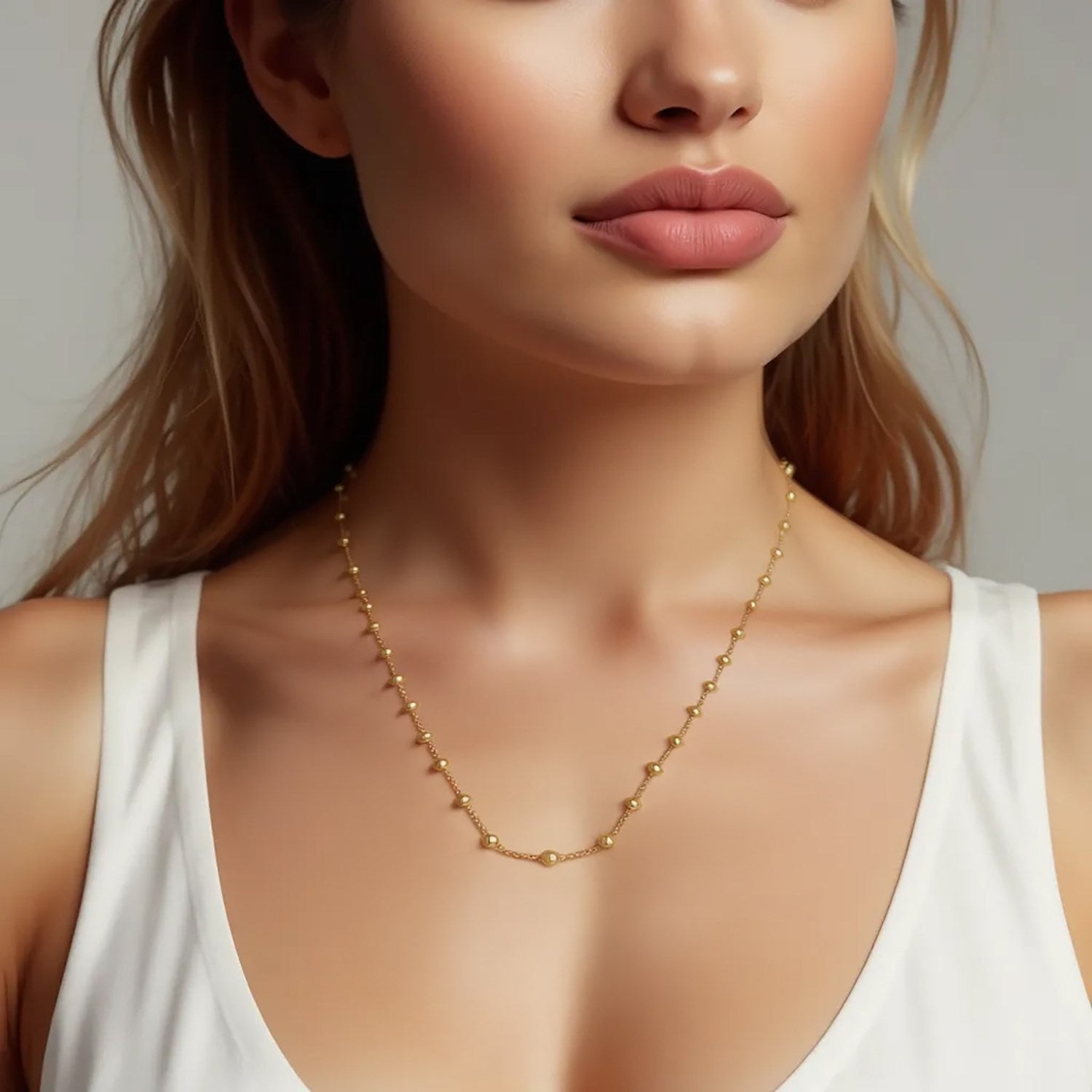 Elegant layering Saturn bead necklace in 14k yellow gold with a refined round chain design.